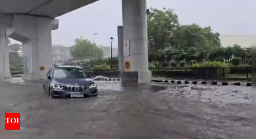 delhi-rains-bring-chaos:-bmw-sedan-gets-stranded-on-waterlogged-road;-traffic-snarls-across-ncr-–-watch