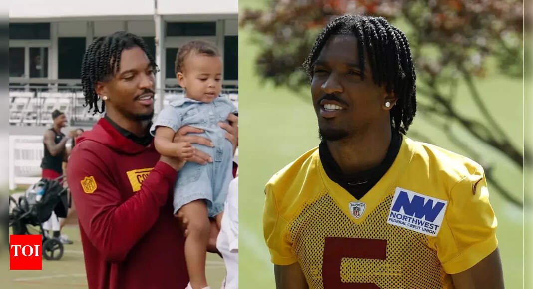 jayden-daniels-hilariously-struggles-to-hold-baby-during-commanders-practice-in-must-see-viral-moment