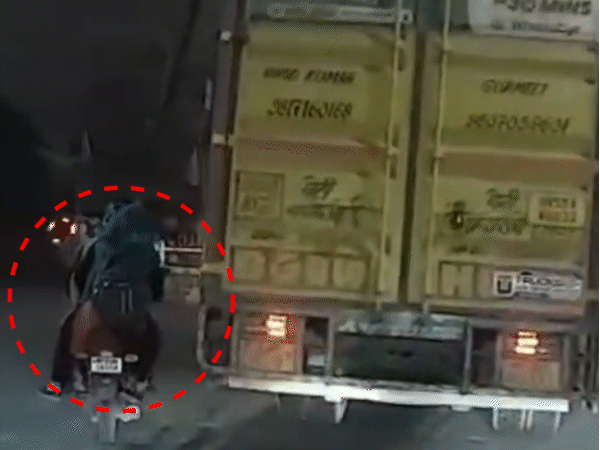 bike-crushed-under-container-during-sudden-turn-in-indore:young-man-and-woman-escape-major-harm-police-seize-vehicle,-after-driver-arrested-following-cctv-video